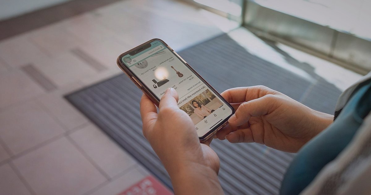 2026'da Dropshipping Karlılık Hesaplama: Nihai Rehberiniz - person holding smartphone showing shopping app cart items