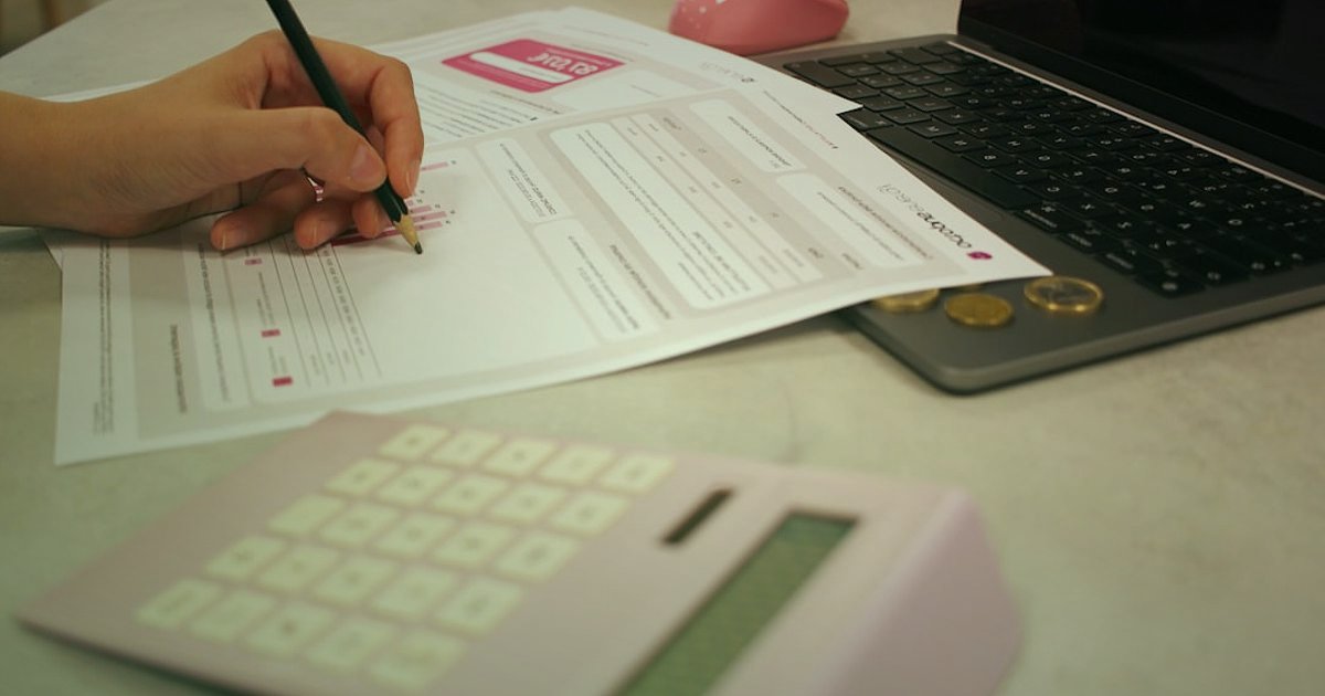 2026'da Dropshipping Kâr Hesaplama: Gizli Maliyetleri Ortaya Çıkarın! - person filling out tax forms at a desk