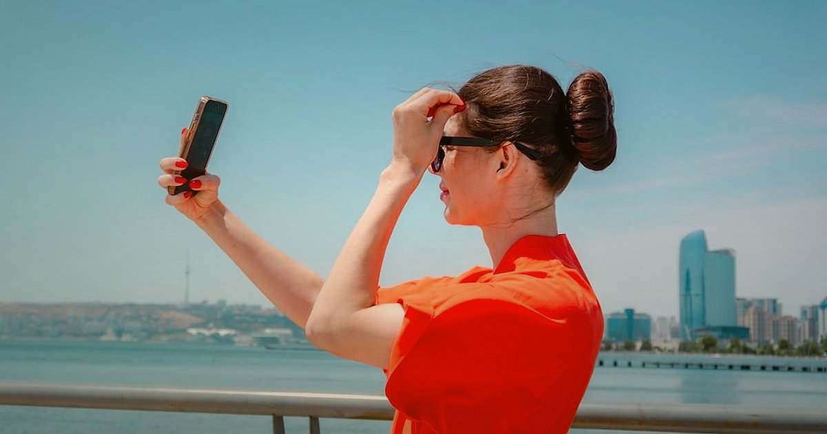 2026'da E-Ticaret Sektöründeki Yenilikler: Dijital Ticareti Dönüştüren Trendler - Woman using smartphone AR app to virtually try on sunglasses