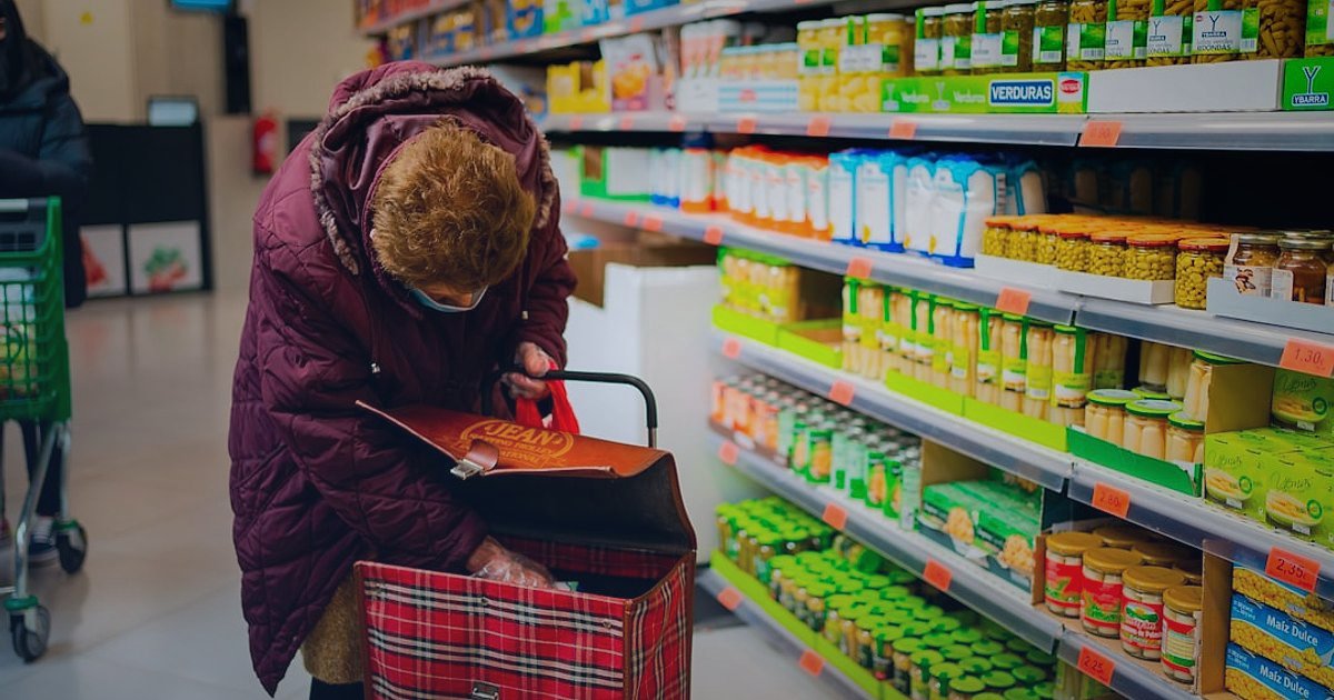 2026'da Kedi Maması Alıcısını Anlamak: Kimler Satın Alıyor ve Neden? - close-up of a woman's hand selecting a bag of cat food in a supermarket