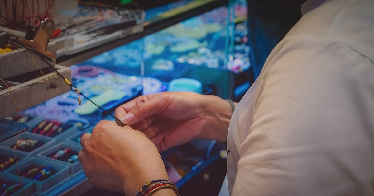 Altın Bilezik Satışında Doğru Pazaryeri: Komisyon, Rekabet ve Puan Dengesi (2026) - close-up shot of a jeweler examining a gold bracelet
