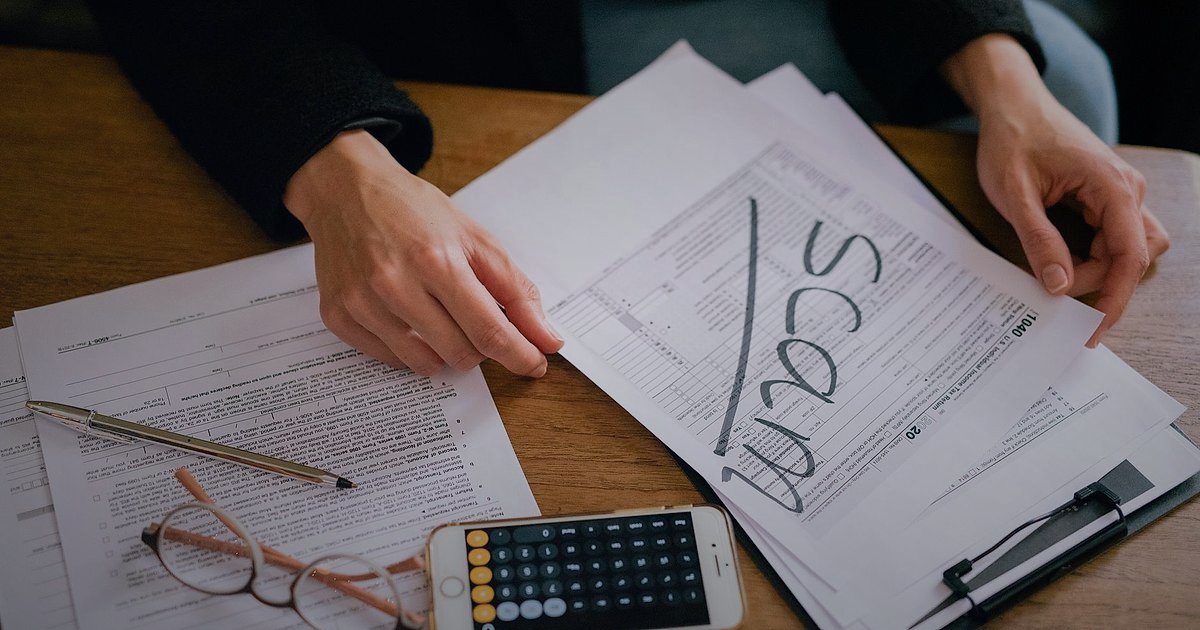 Ayakkabı & Çanta Dropshipping: 2026'da Başlangıç Hataları ve Çözümleri - person reviewing legal documents at a desk with calculator