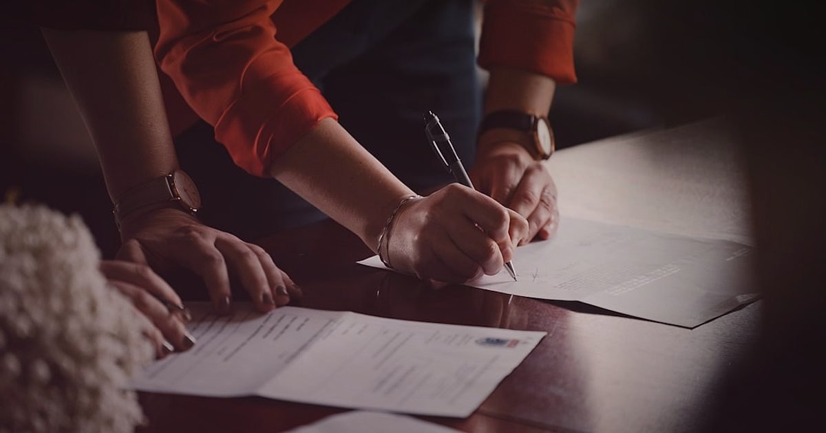 Bayilik Sözleşmesinde Dikkat Edilmesi Gerekenler 2026: Hukuki ve Ticari Güvence - two business partners signing contract agreement table