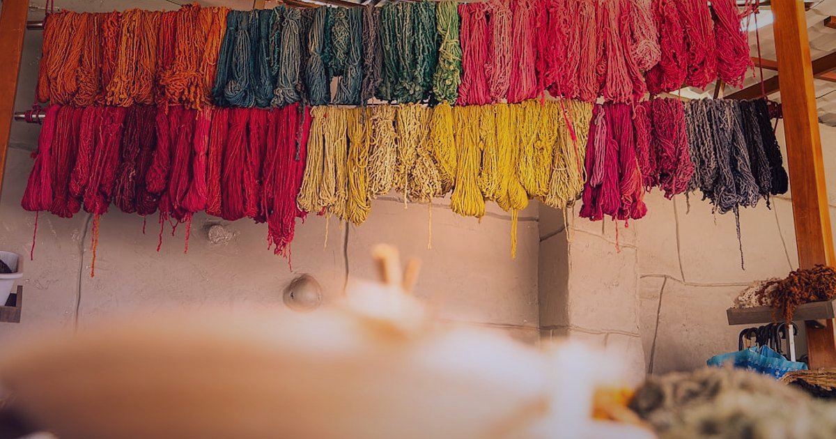 Çarşaf Satışında Başlangıç Hataları: 2026'da Karlı Bir E-Ticaret İçin Kritik İpuçları - woman carefully examining cotton fabric swatches in a brightly lit textile workshop