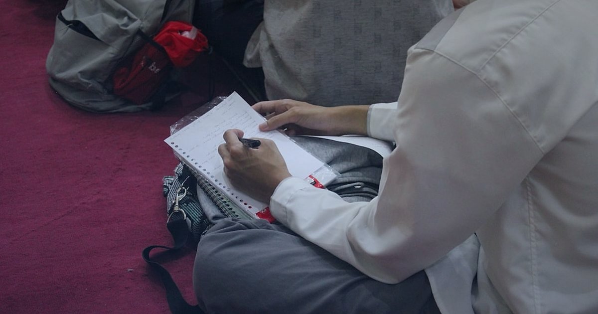 Dijital Pazarlama Başarı Stratejileri 2026: Gelirinizi Katlayın! - person writing on a notebook surrounded by books