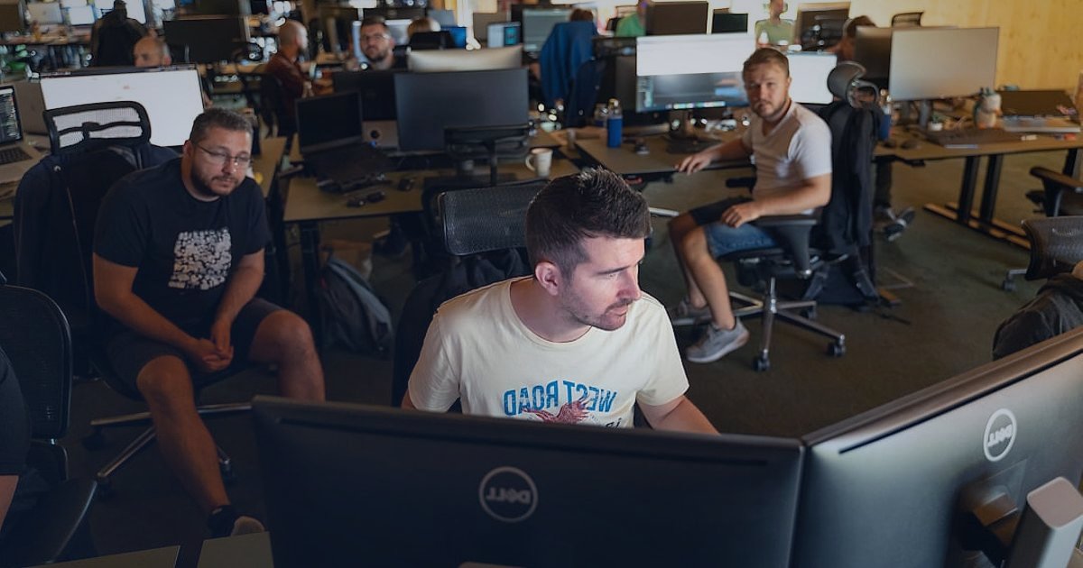 Dropshipping Avantajları & Dezavantajları 2026: Karlı Bir Başlangıç Rehberi - diverse team collaborating around a large monitor displaying website analytics