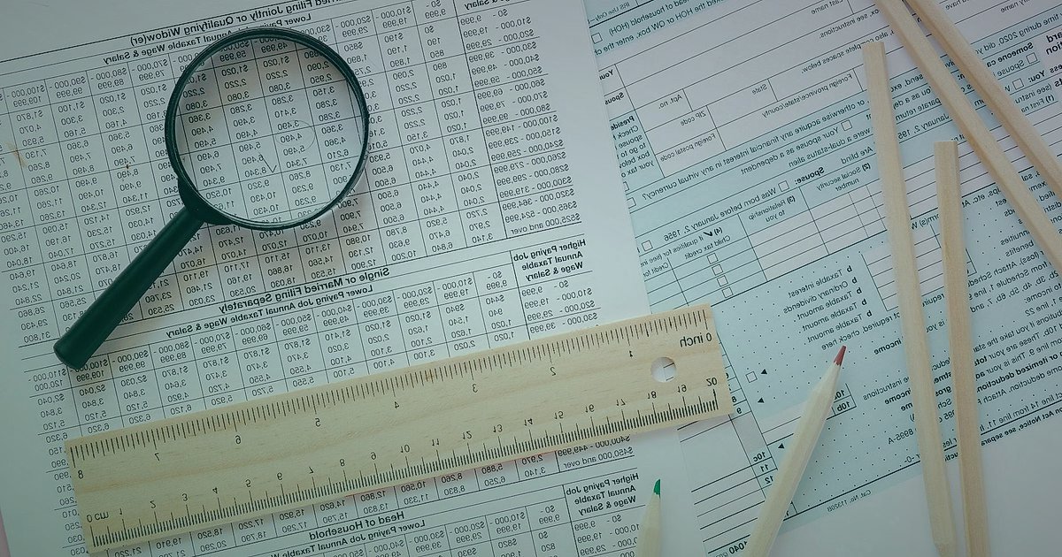 Dropshipping Karlılık Hesaplama 2026: Kârınızı Maksimize Edin! - magnifying glass over scattered invoices