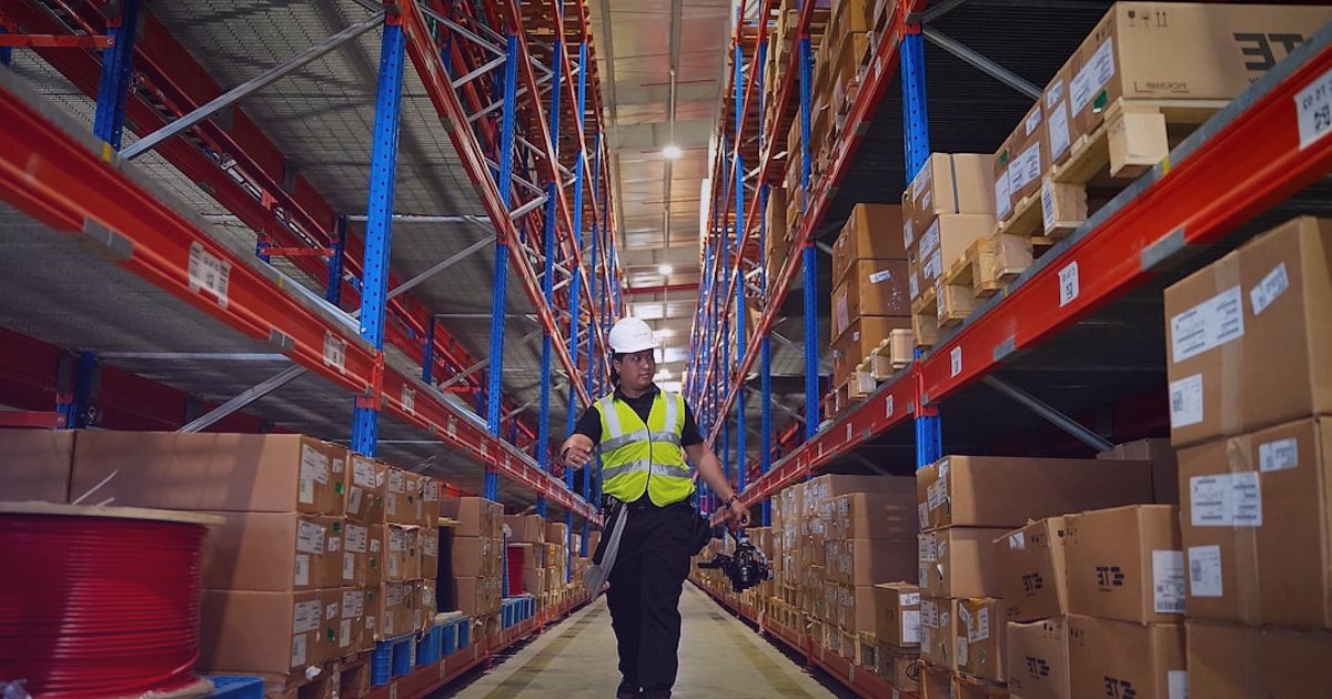 Dropshipping Nedir 2026? Stoksuz Satışla E-Ticarette Devrim Yaratın! - woman examining product samples warehouse shelves