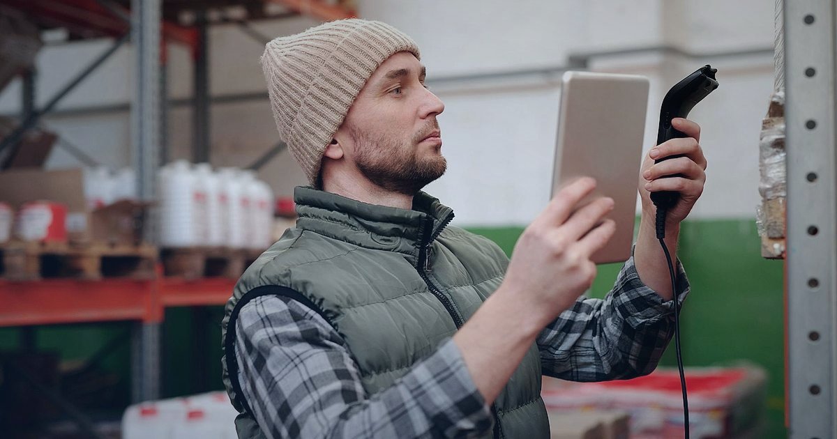 Dropshipping Nedir 2026? Stoksuz Satışla Kârınızı Maksimize Edin! - Woman scanning barcode on warehouse shelves with a handheld scanner
