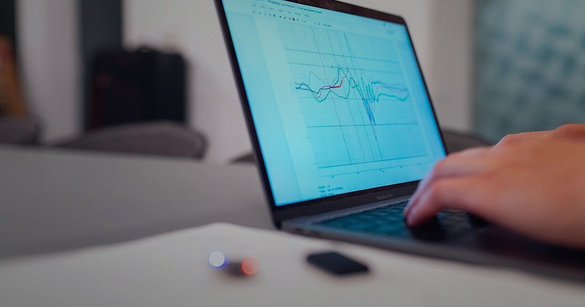 Dropshipping Nedir 2026? Stoksuz Satışla Kârınızı Maksimize Edin! - Person typing on a laptop with financial charts and graphs displayed on screen