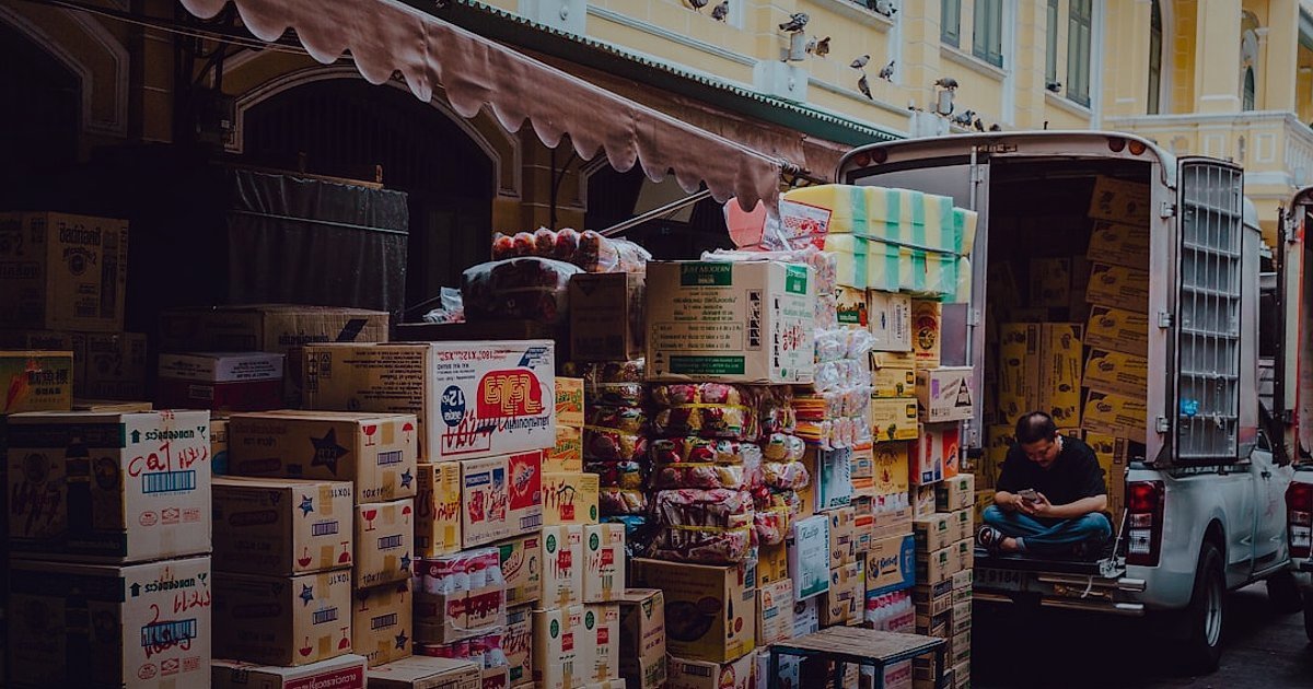 Dropshipping Nedir 2026? Stoksuz Satışla Kârınızı Maksimize Edin! - Delivery truck parked at a loading dock with packages being loaded at sunrise