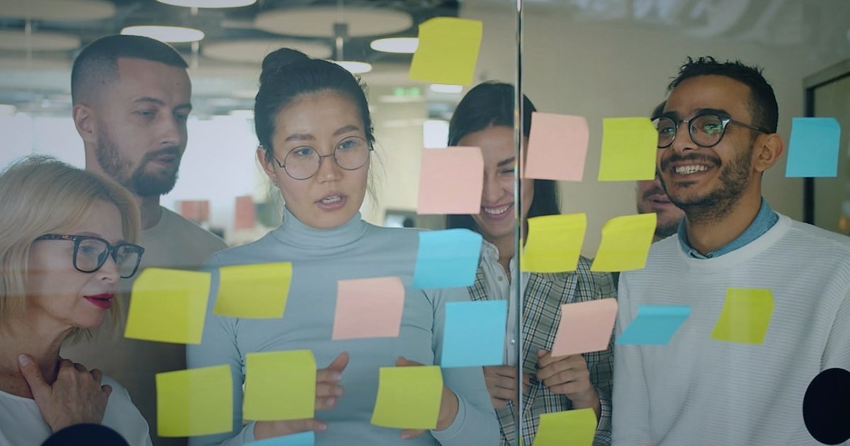 Dropshipping Nedir 2026? Stoksuz Satışla Kârınızı Maksimize Edin! - Team of diverse people collaborating around a whiteboard with sticky notes