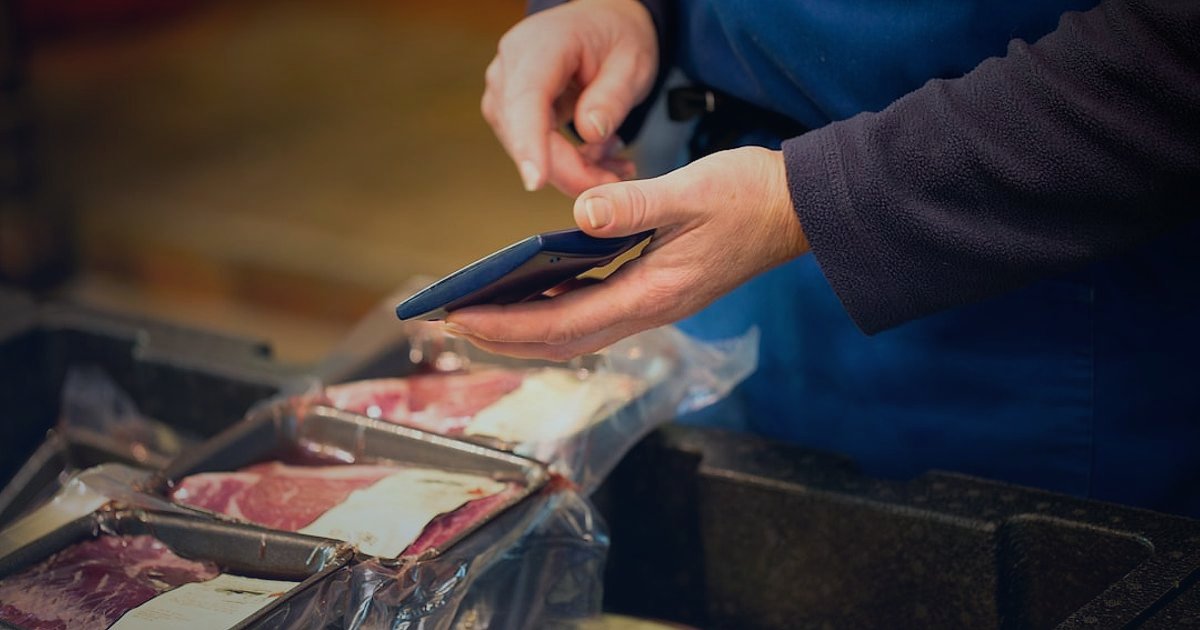 Dropshipping Nedir 2026? Stoksuz Satışla Kârınızı Maksimize Edin! - Person scanning a QR code on a product package with their smartphone