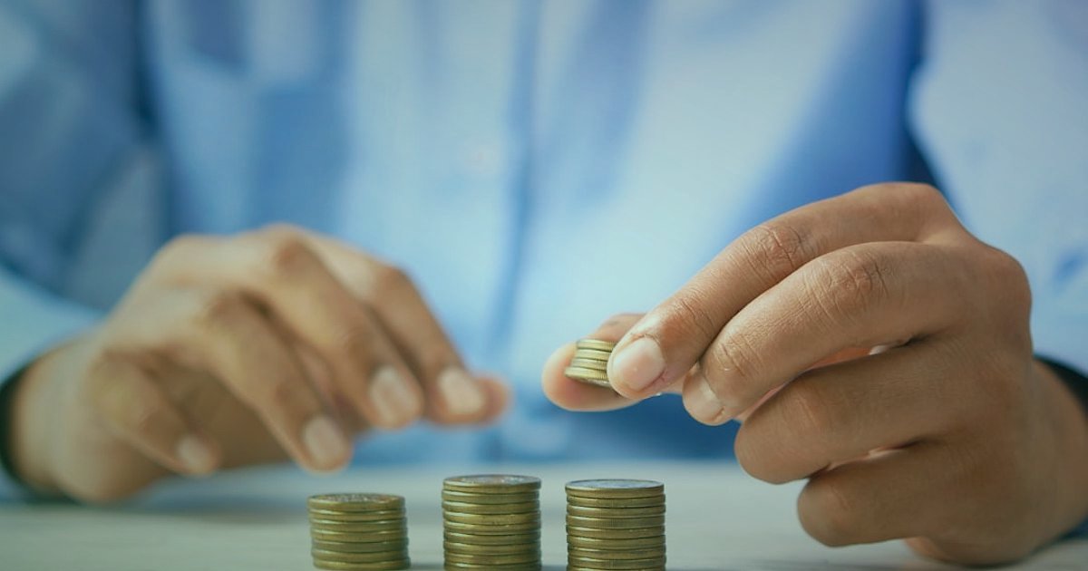 Dropshipping.gen.tr: 2026'da Stoksuz Satışın Avantajları ve Başlangıç Rehberi - overhead view of a hand placing a single coin on a stack of coins on a wooden table