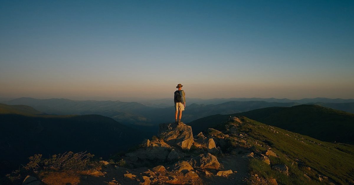 Dropshipping.gen.tr: 2026'da Stoksuz Satışın Avantajları ve Başlangıç Rehberi - person standing on a mountaintop with arms raised, overlooking a vast landscape at sunrise