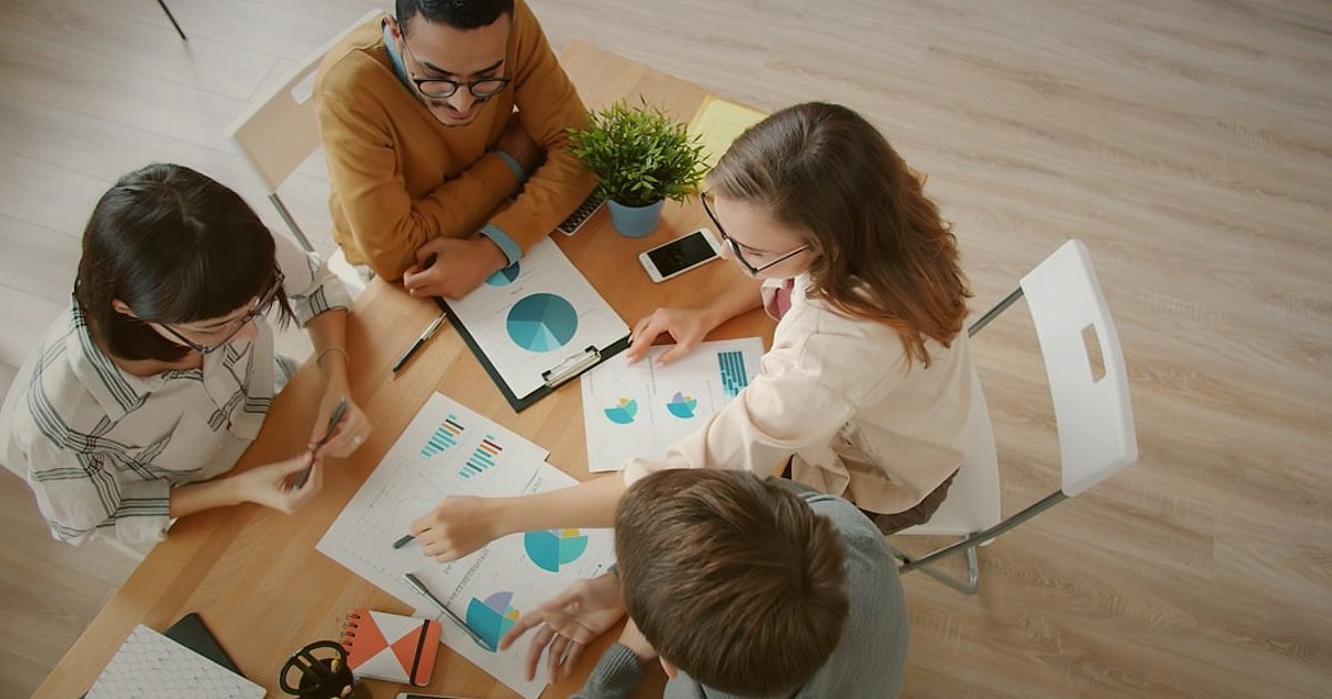 Dropshipping.gen.tr Avantajları 2026: Neden E-Ticarette Lideriz? - diverse group of people collaborating around a digital tablet displaying growth charts