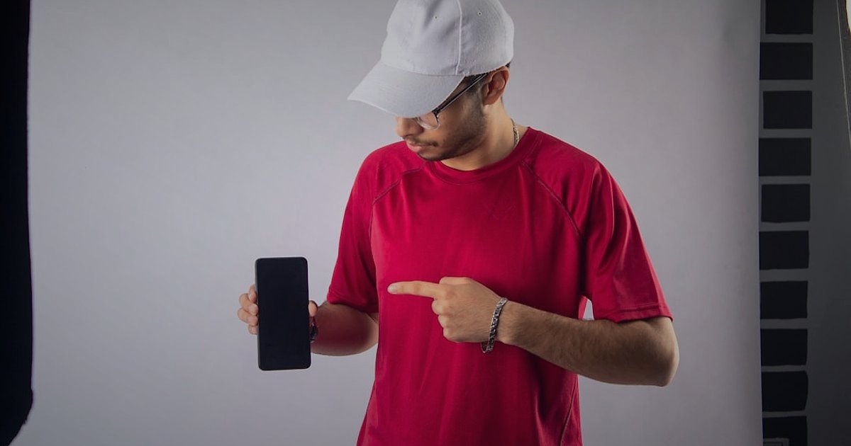E-Ticarette Ürün Fotoğrafçılığı: 2026'da Satışlarınızı Uçuracak Görsel Stratejiler - person taking a product photo with a smartphone using a portable light box