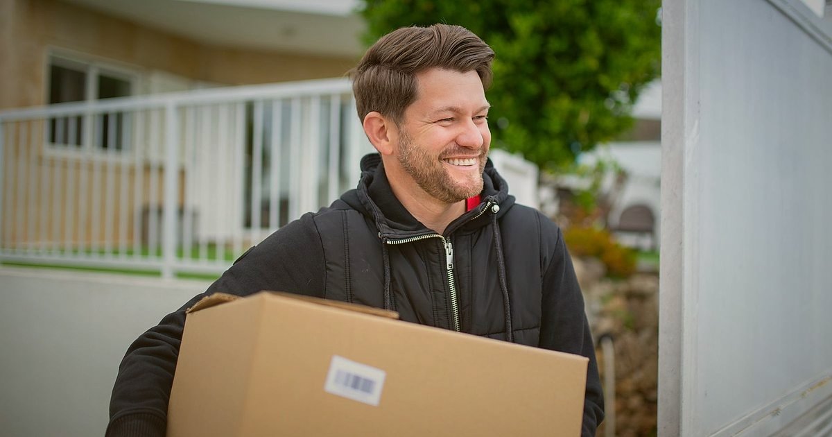 Erkek Giyim Dropshipping: 2026'da Kargo, Paketleme ve Teslimat Çözümleri - delivery courier smiling holding men's apparel package at customer's doorstep