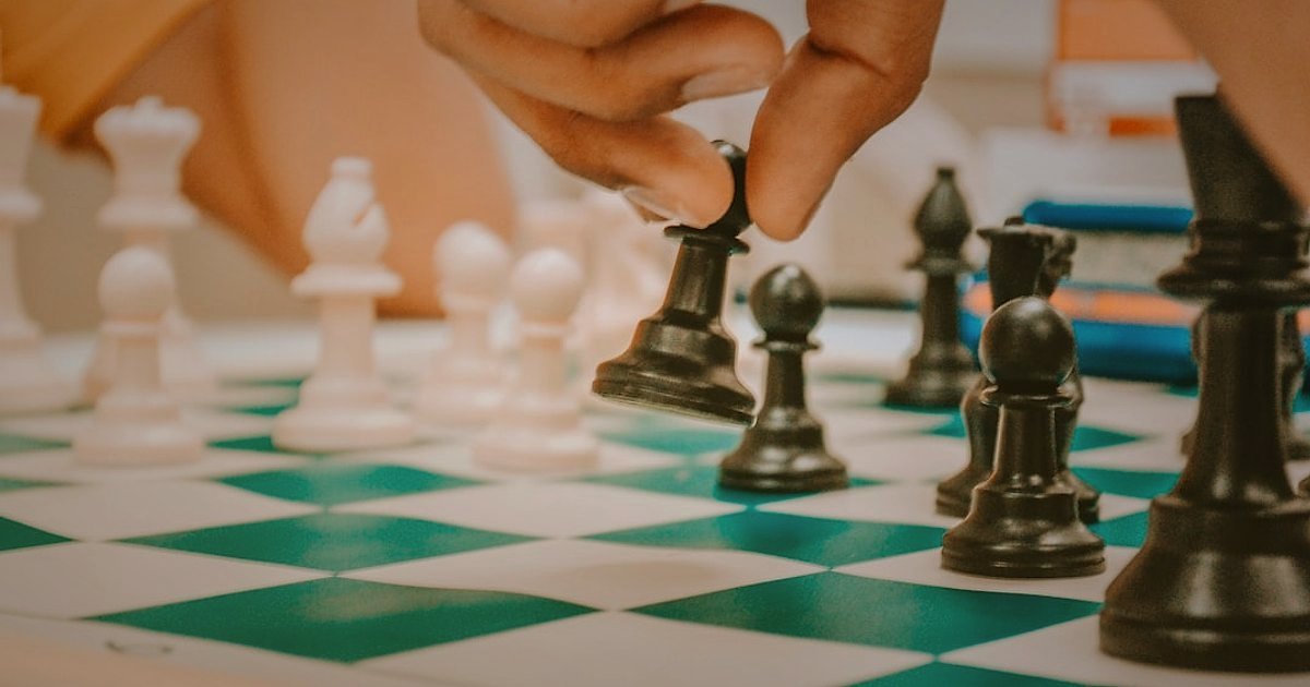 Harici Disk & SSD Fiyatlandırma Sırları: 2026'da Kâr Marjınızı Maksimize Edin - person placing chess pieces on chessboard strategic setup