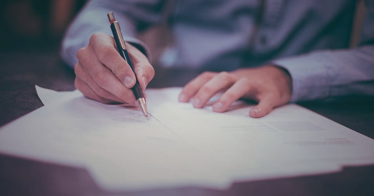 Hijyenik Ped Tedarikçisi Bulma ve Doğrulama: 2026 Güven Sinyalleri - person signing a contract on a desk with a pen