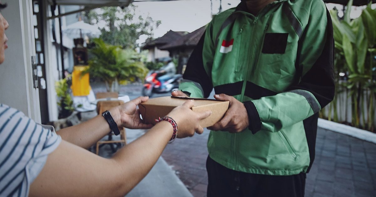 Kargo Hasarında Tazminat Süreci 2026: Bayi Hakları ve Adım Adım Rehber - delivery driver handing damaged package customer porch