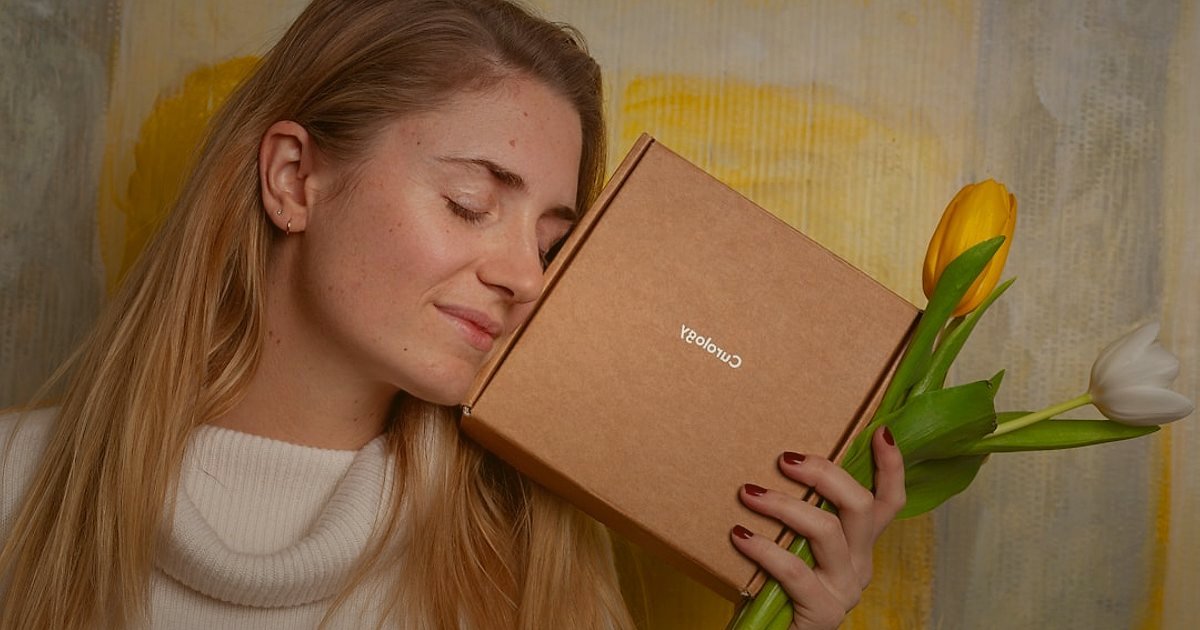 Küpe Alıcısını Anlamak: 2026'da Kimler Neden Satın Alıyor? - woman happily unboxing a small jewelry gift box