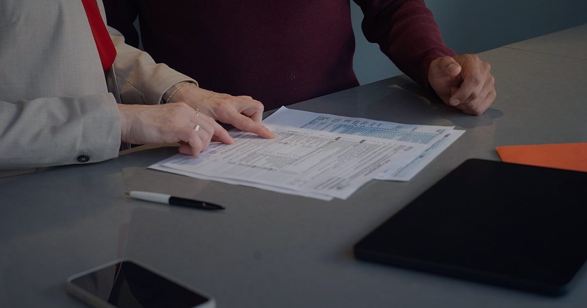 Mesafeli Satış Sözleşmesi Hazırlama Rehberi 2026: E-Ticarette Güvenliği Artırın! - woman reviewing contract papers office desk