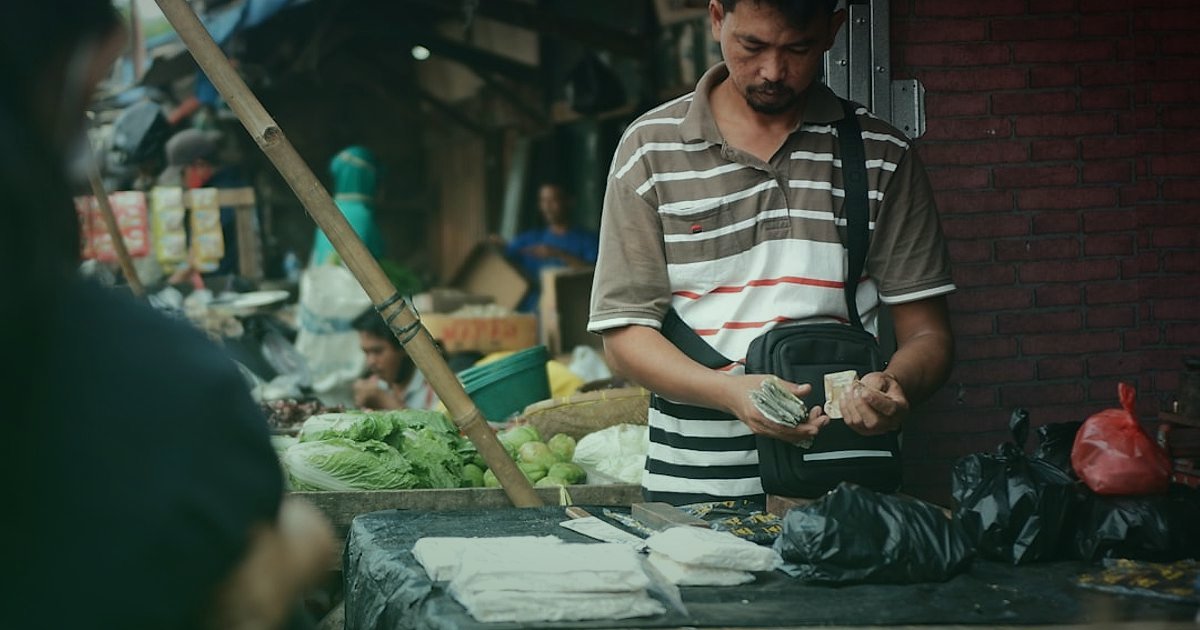Mikro Niş Dropshipping: 2026'da Düşük Rekabetle Yüksek Kâr Fırsatları! - person setting up a small stall in a bustling but open-air market, digital tablet showing online store