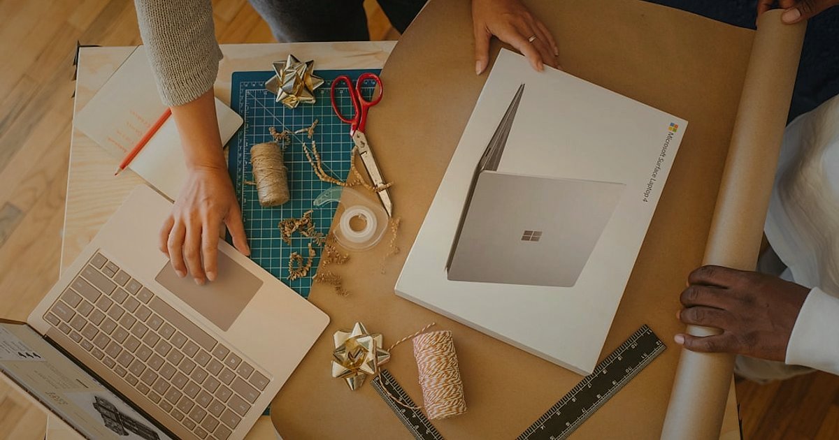 Mikro Niş Dropshipping: 2026'da Düşük Rekabetle Yüksek Kâr Fırsatları! - diverse group of people discussing product samples around a table, laptop open with supplier website