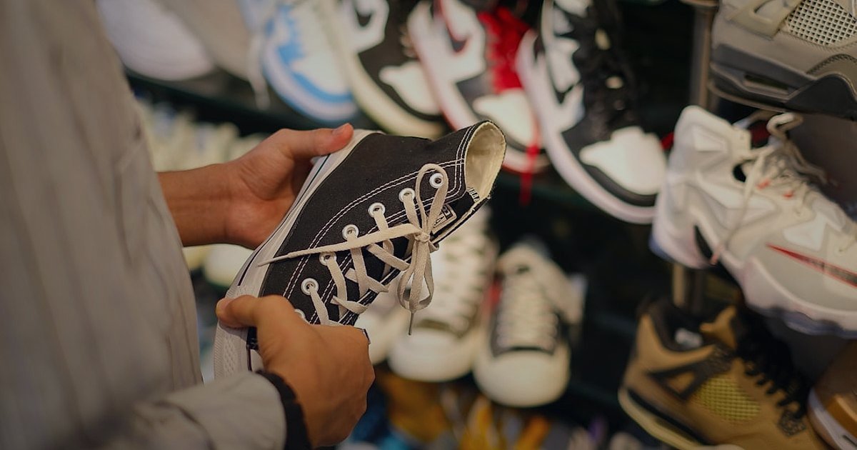 Spor ve Outdoor Ekipmanları Satış Stratejileri 2026: Rekabette Zirveye Oynayın! - person comparing price tags on various sports apparel items