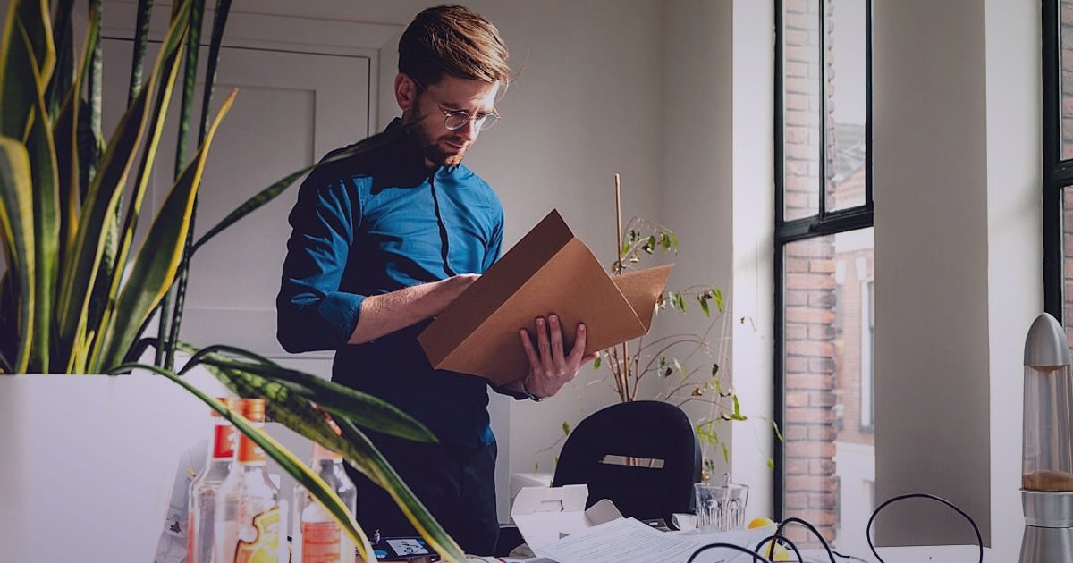 Telefon Aksesuarları İade Yönetimi 2026: Müşteri Memnuniyetiyle Büyüme Stratejileri - person carefully examining product return label shipping box
