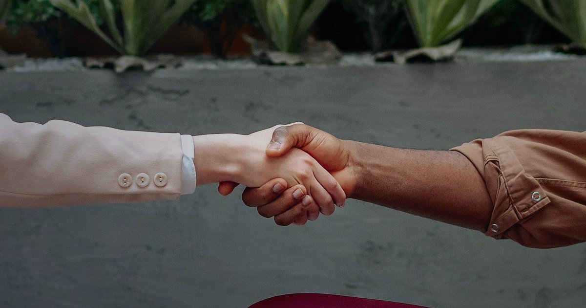 Tükenme Riskini Sıfırlayın: Bulmaca & Puzzle Dropshipping'de Sürekli Tedarik Zinciri 2026 - two suppliers shaking hands in a modern warehouse setting