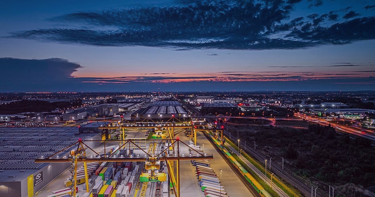 Tükenme Riskini Sıfırlayın: Bulmaca & Puzzle Dropshipping'de Sürekli Tedarik Zinciri 2026 - drone flying over a vast logistics hub at sunset