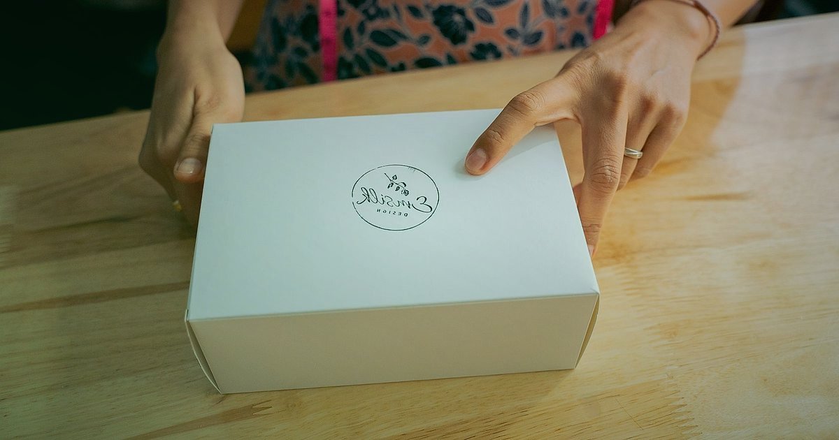 Ürün Paketleme ve Unboxing Deneyimi Tasarımı 2026: E-Ticarette Zirveye Çıkın! - designer sketching custom brand logo on packaging mockups